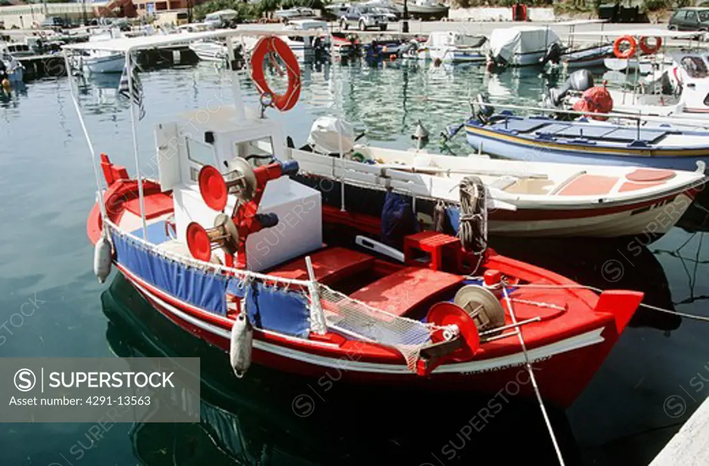 Small red fishing boat moored in the harbour of Argostoli on the island of Kefalonia in Greece