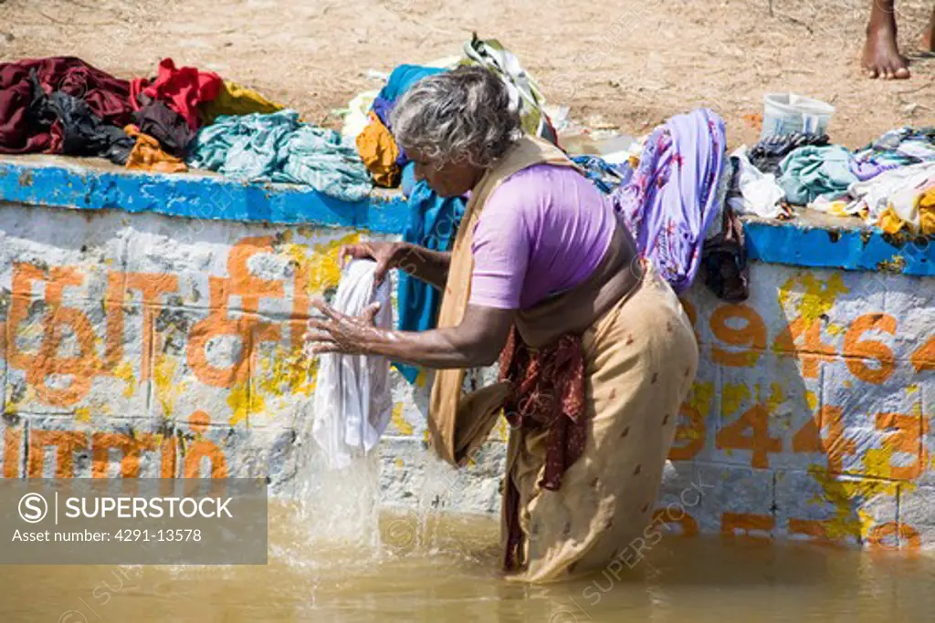 Woman washing clothes in a river, Tamil Nadu, India