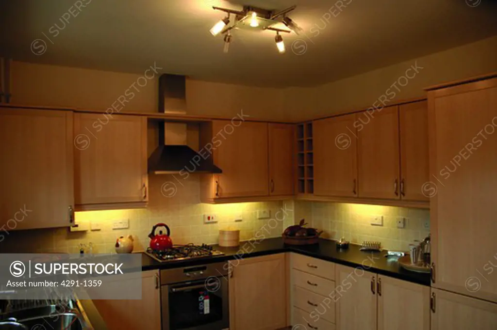 Recessed lighting below wall-cupboards in modern kitchen