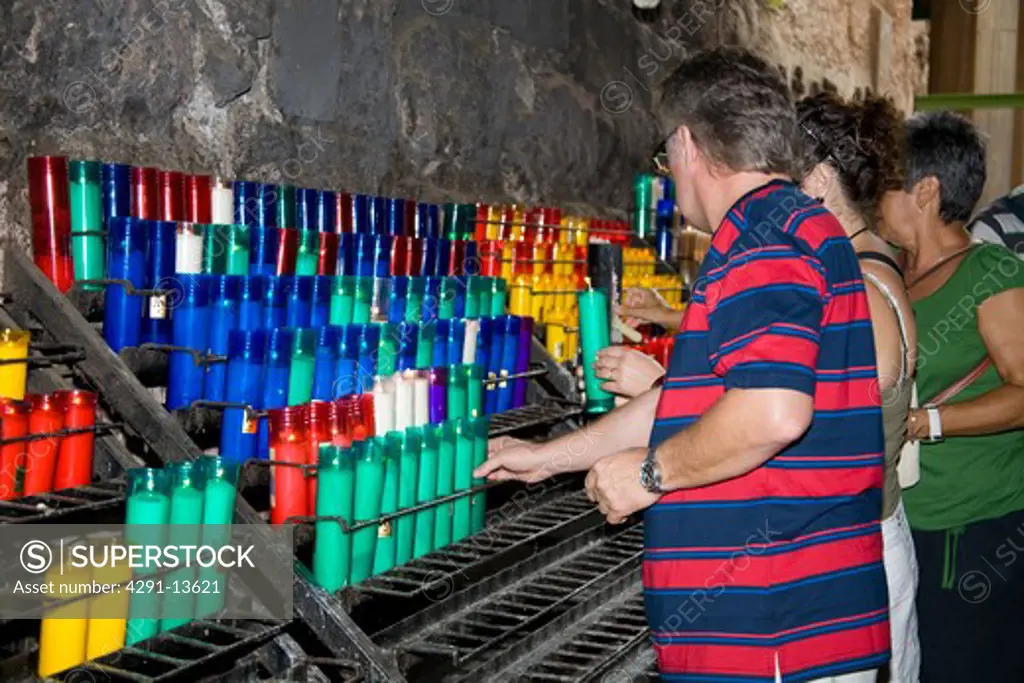 Worshippers lighting candles inside Montserrat Basilica, Montserrat, near Barcelona, Spain