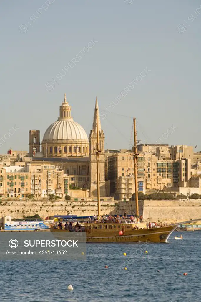 Large yacht cruising in front of old builings in Sliema harbourin Valletta on the island of Malta