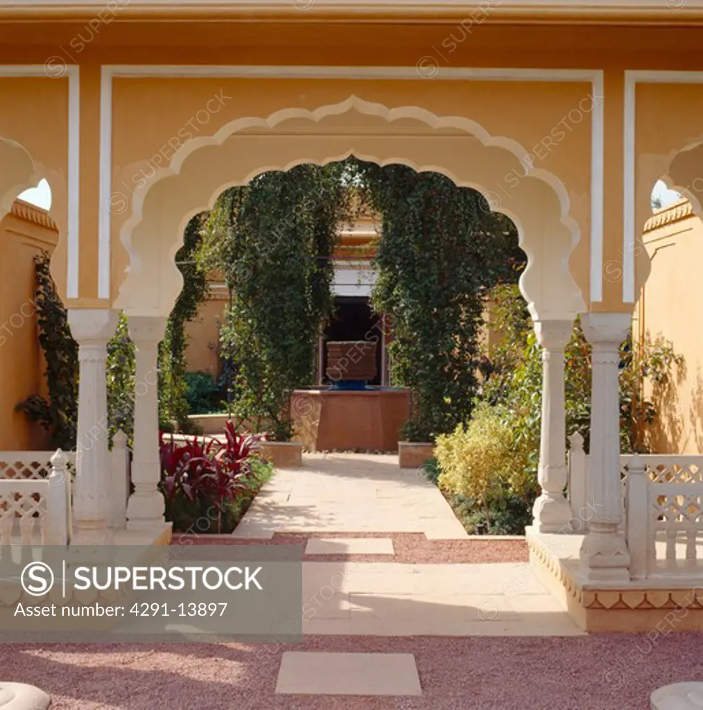 Ornate arch and view of tranquil courtyard at the Rajvilas Hotel near Jaipur in Rajastan