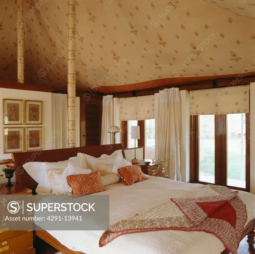 White linen pillows and silk cushions on kingsize bed in bedroom in Rajastani tent
