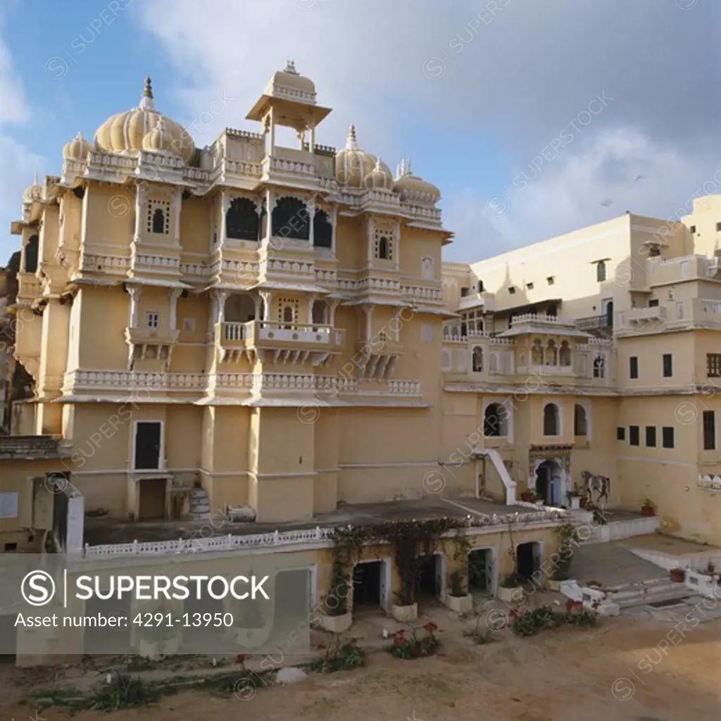Imposing sandstone exterior with balconies and domes of the former palace now the Deogarh Mahal hotel in Rajastan