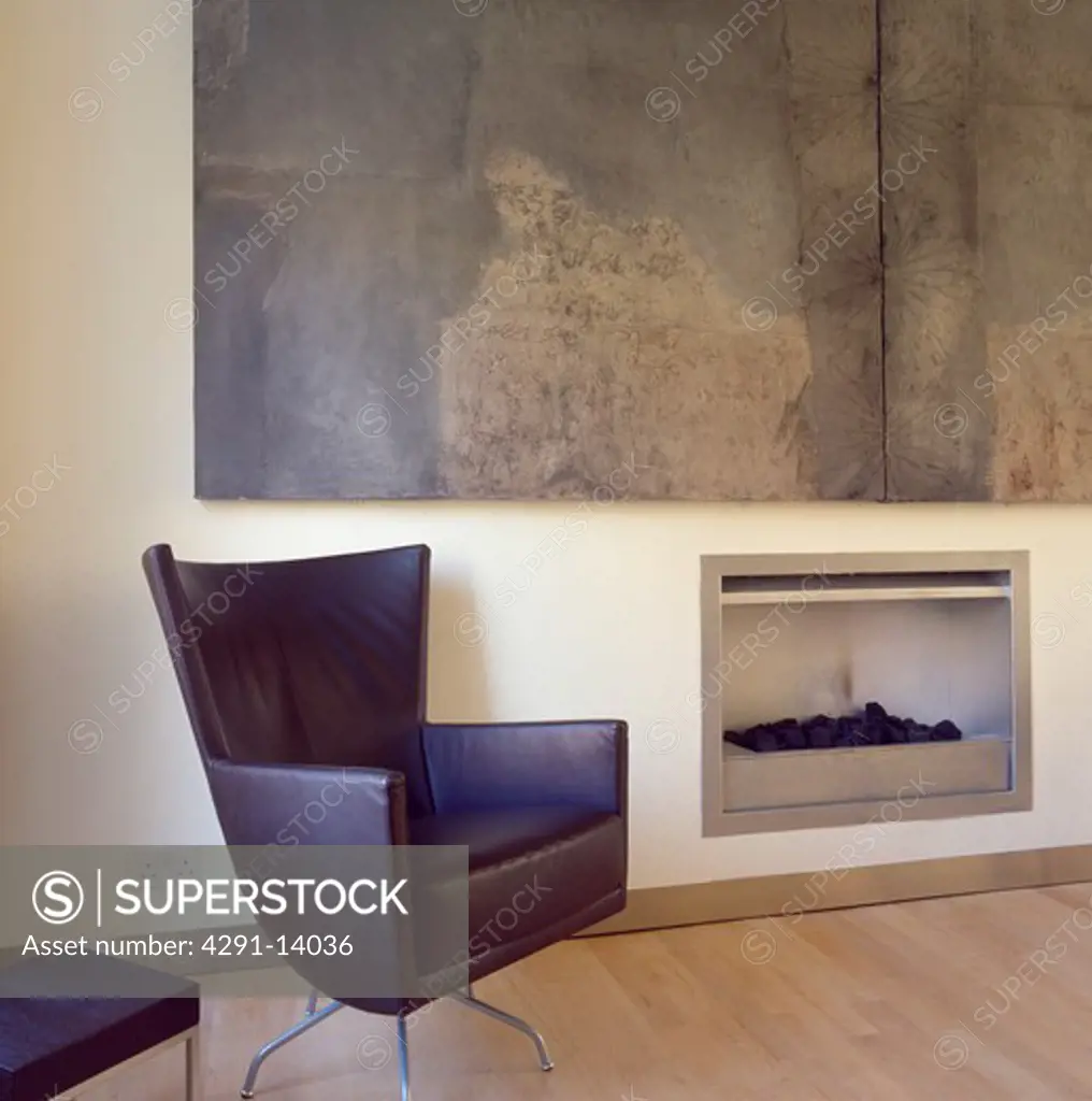 Montis black leather swivel armchair beside fireplace in modern livingroom with large abstract painting by Hannah Biggs