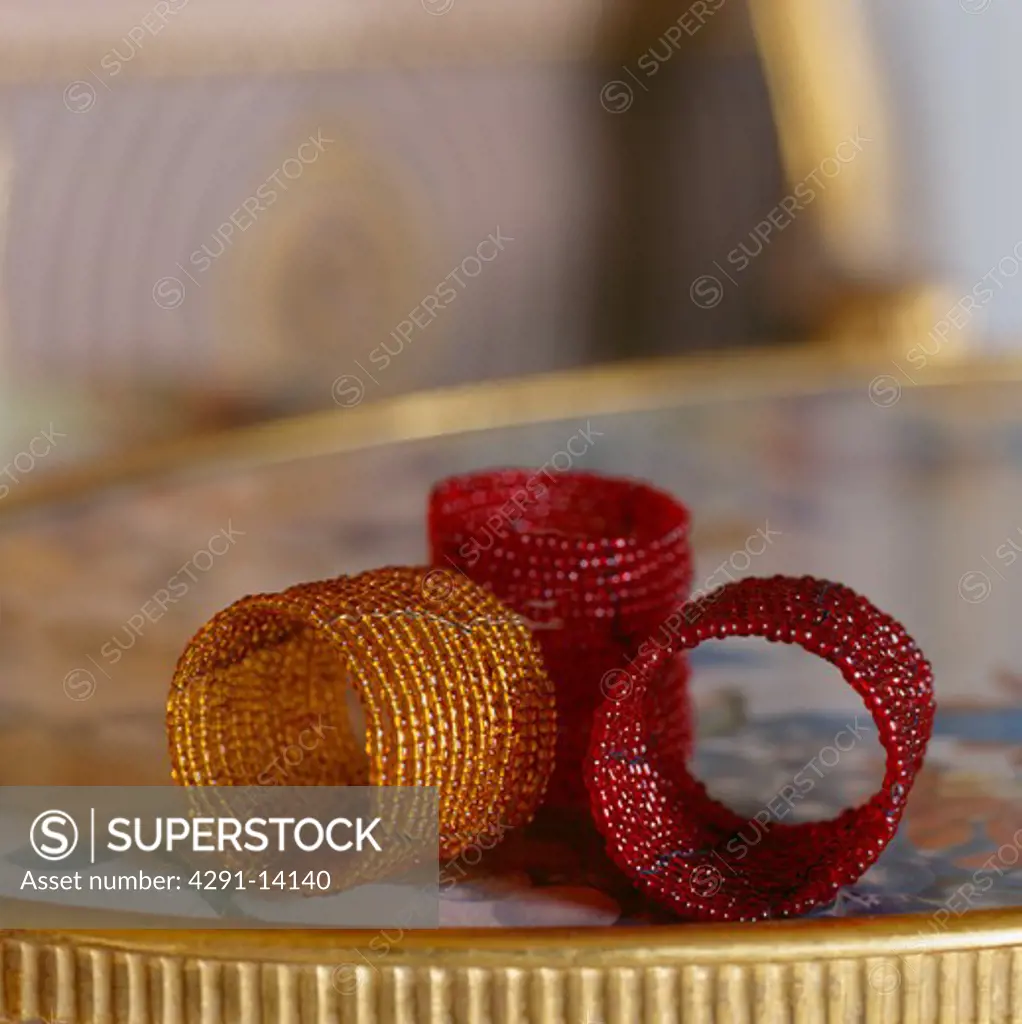 Close-up of bronze and red beaded table napkin rings