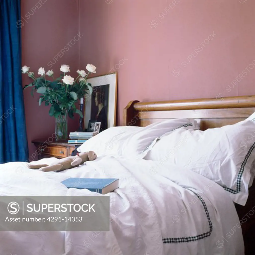 White bedlinen on bed in pink bedroom