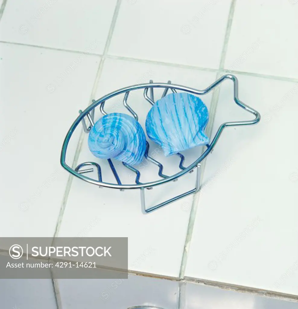 Close-up of blue shell-shaped soap in metal fish-shaped soap-dish