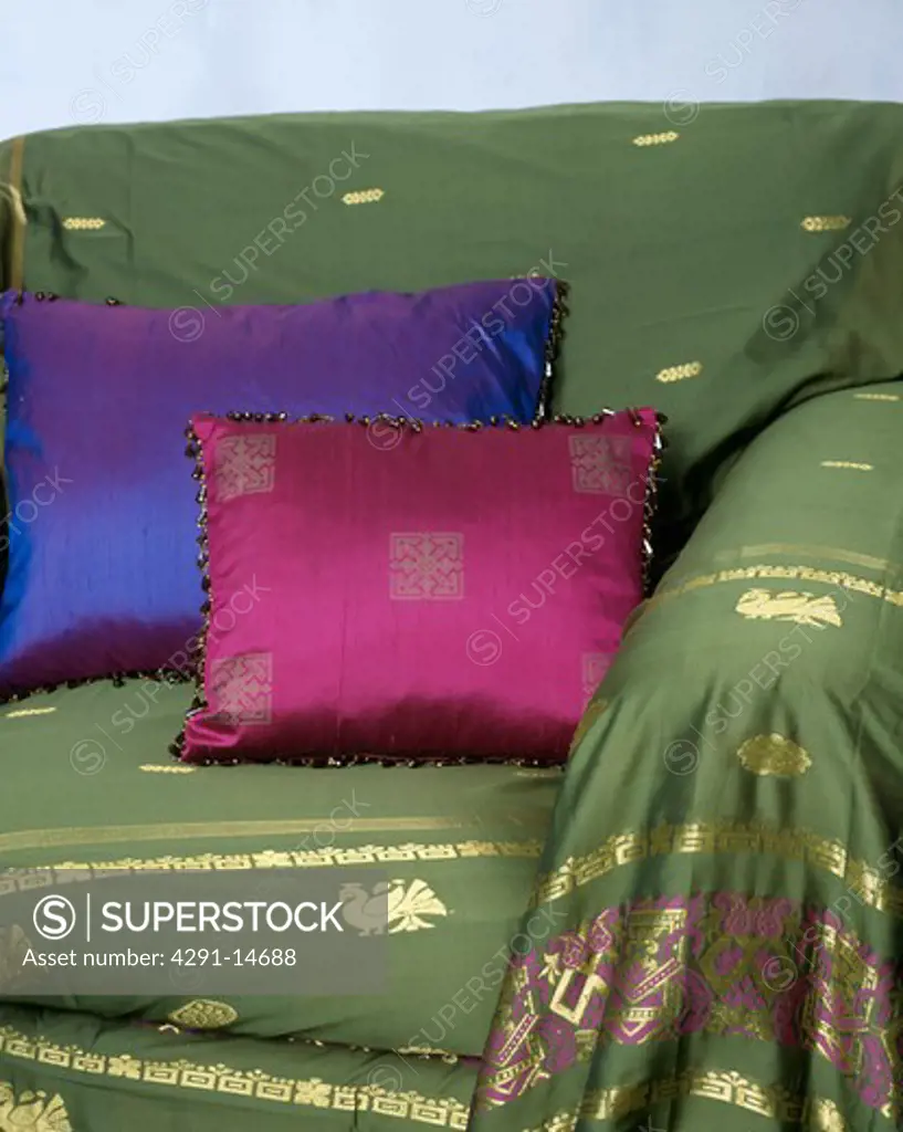 Close-up of silk cushions on sofa with green Indian silk throw
