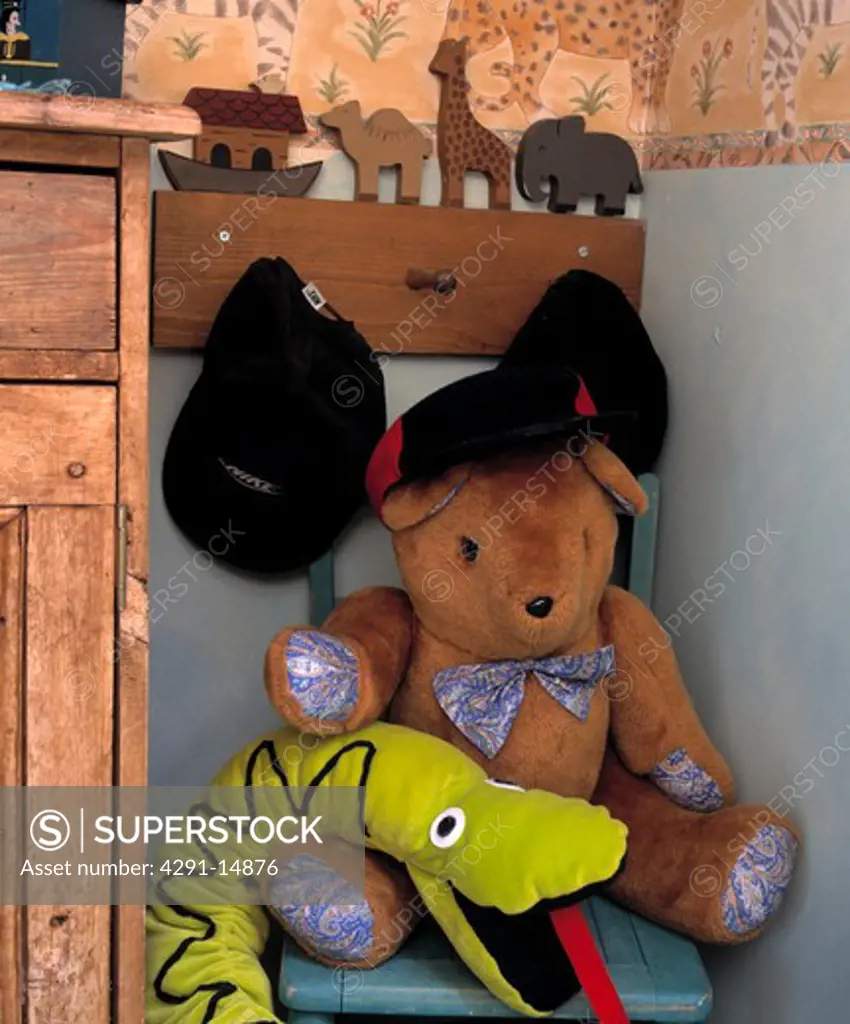 Close-up of Noah's Ark pegboard with boys' caps and teddybear with felt snake