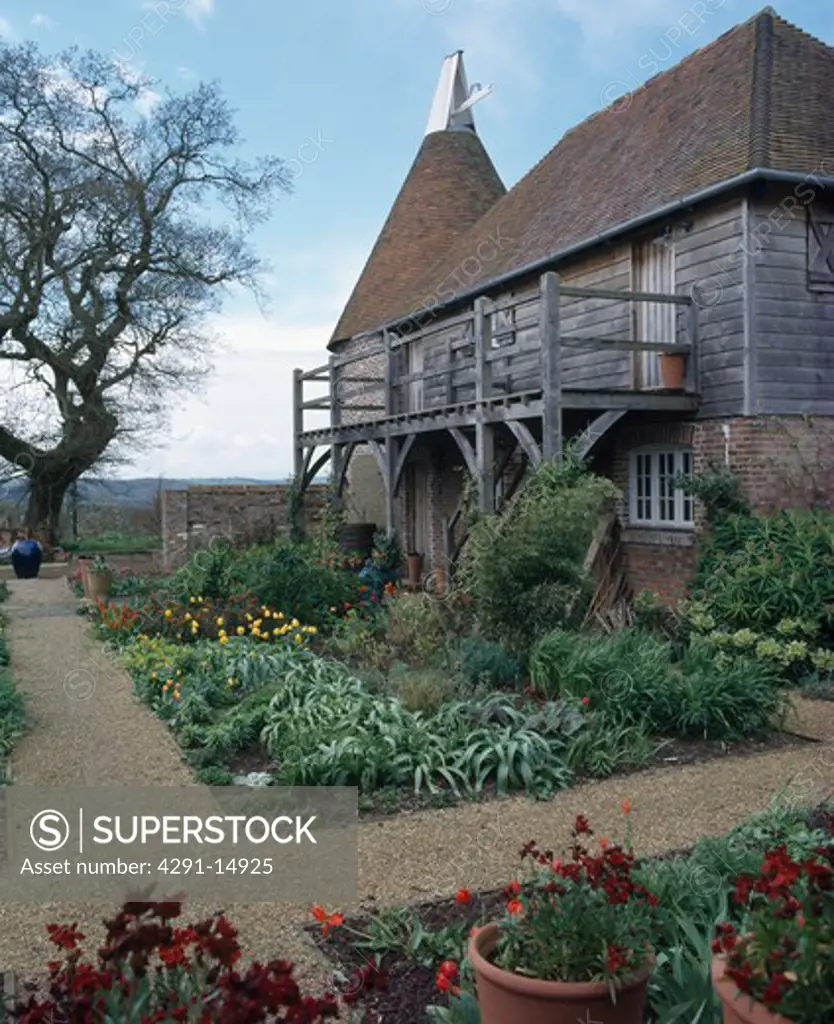 Converted oast house with wooden balcony and garden with gravel paths