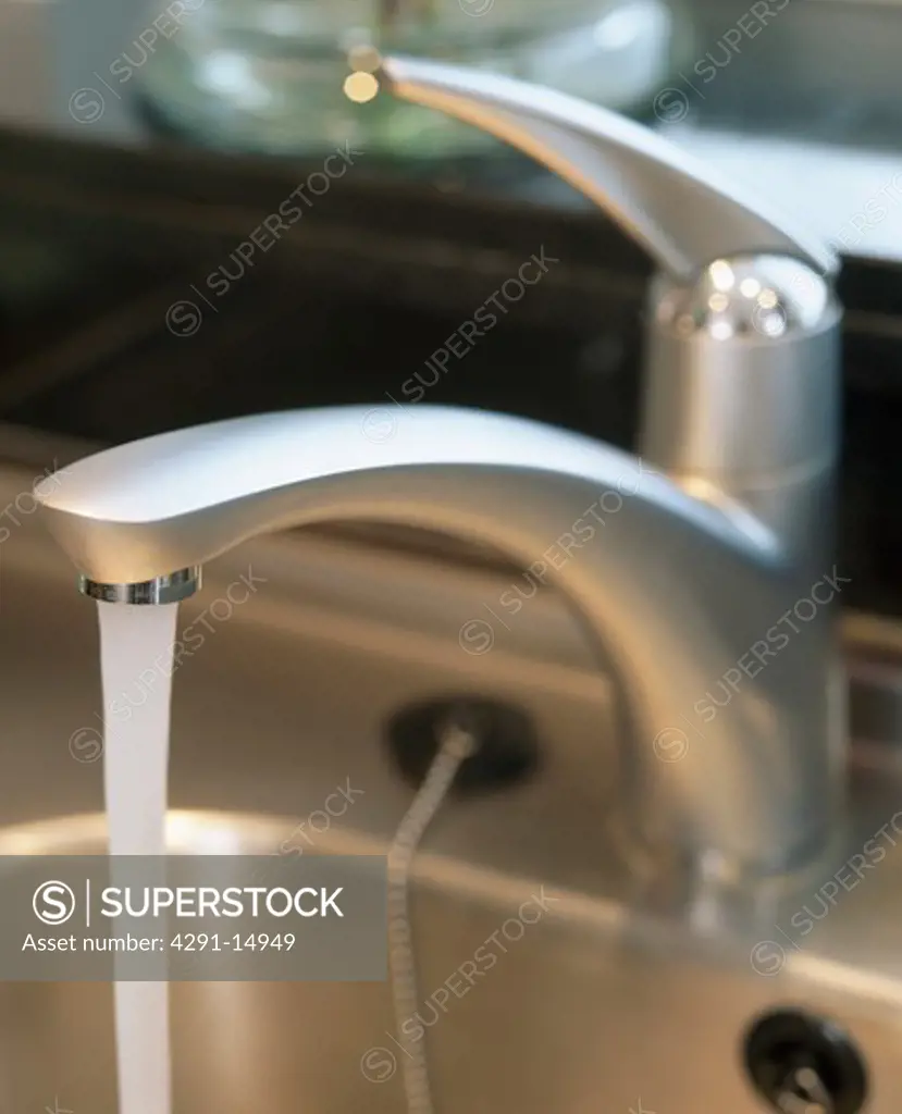 Close-up of water pouring from stainless steel tap