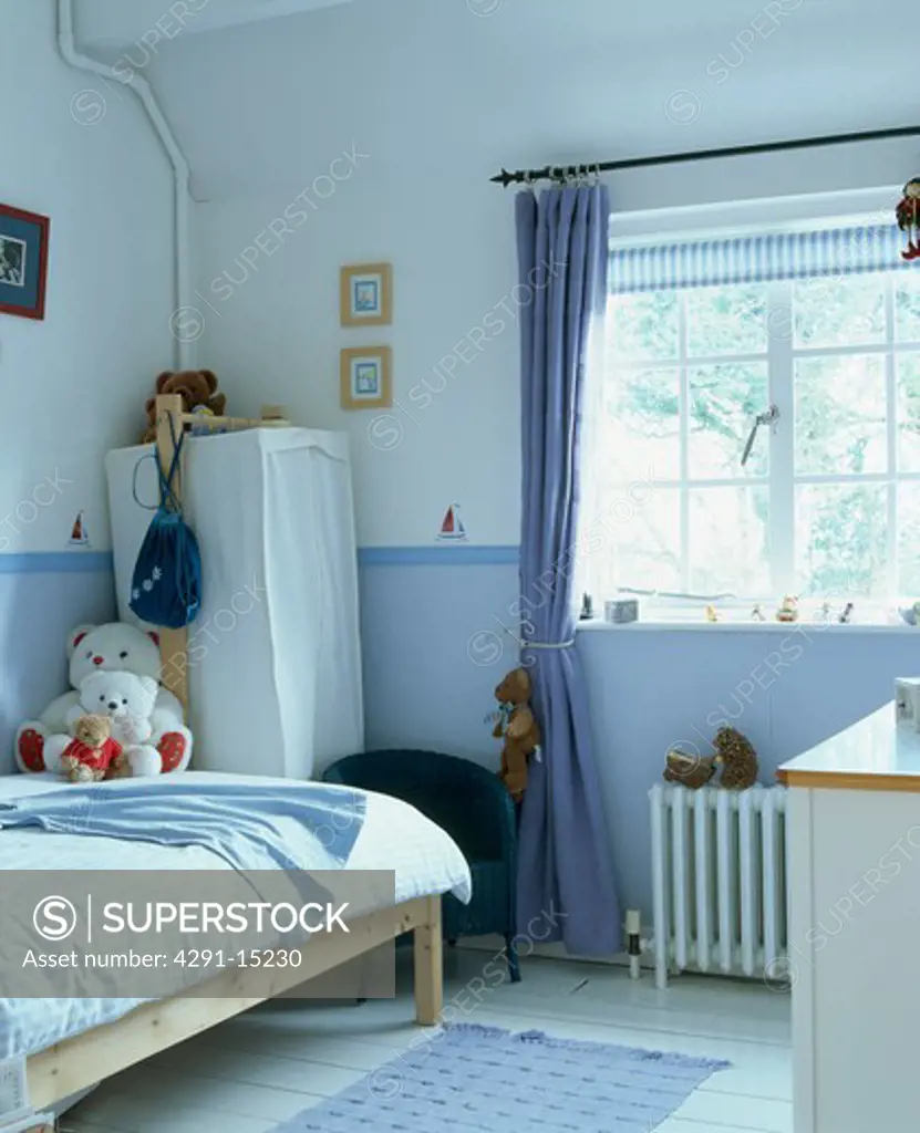 Blue curtain at window in child's blue and white bedroom