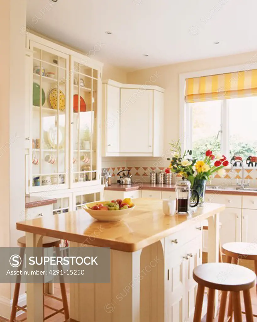 Contemporary white painted wooden kitchen with island unit incorporating breakfast bar