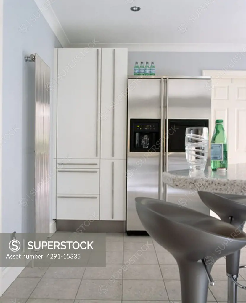 American-style stainless steel refrigerator in modern kitchen with vertical stainless steel radiator