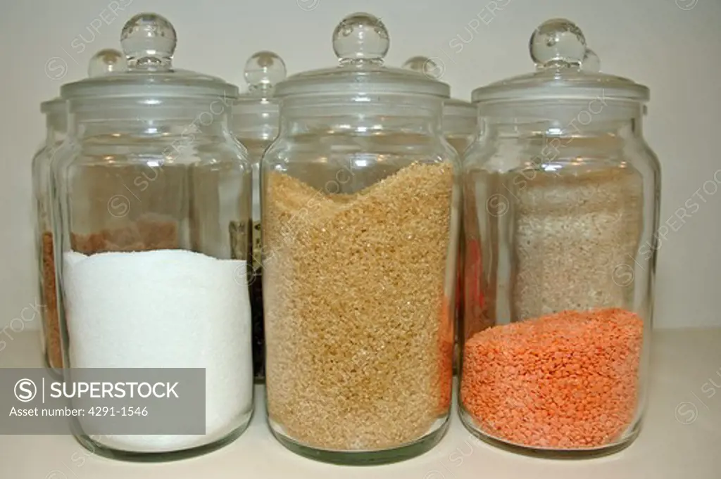 Close-up of glass jars of lentils and sugar
