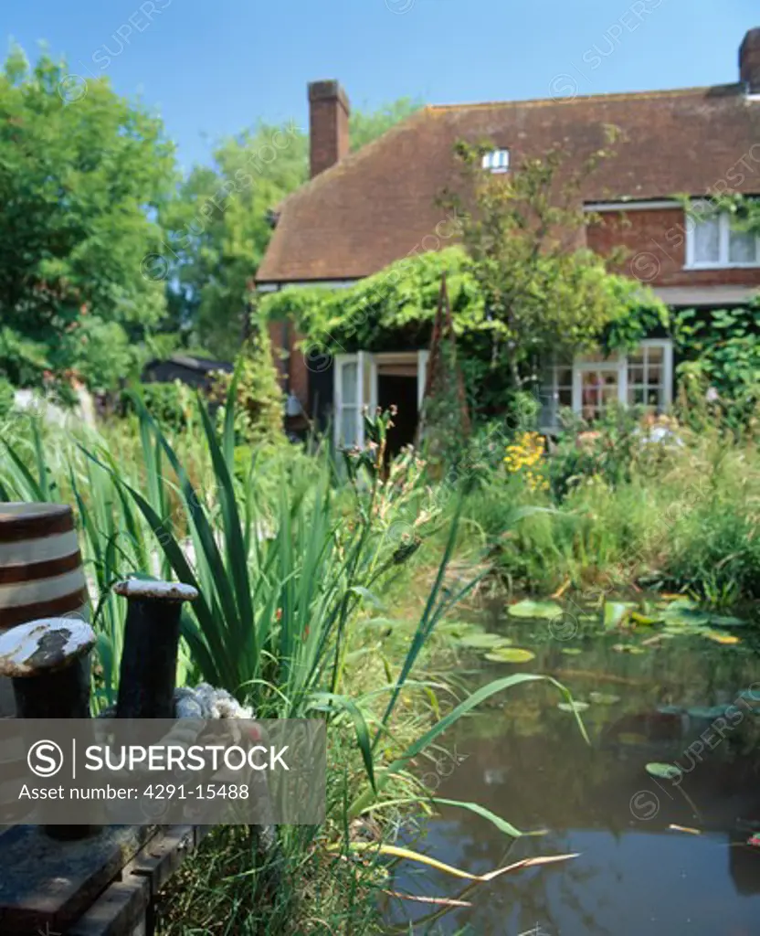 Small natural pool in front garden of country cottage in summer