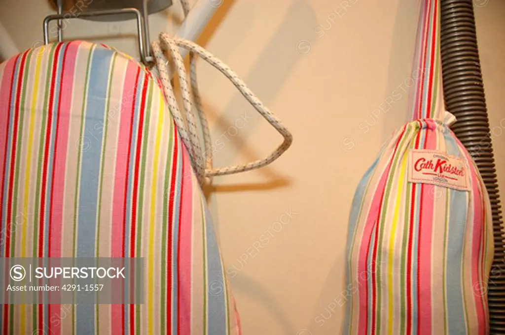 Close up of ironing board with pastel striped Cath Kidston cover and bag