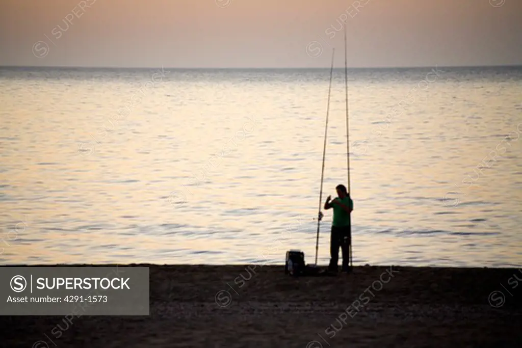 Fisherman beside the ocean at dawn