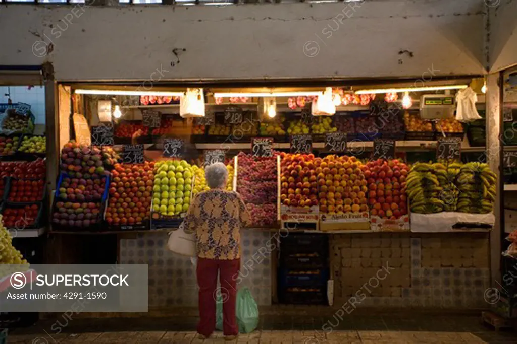 Woman at a fresh fruit and vegetable stall in Spanish street market