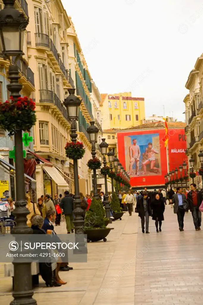 Traditional streetlamps and people walking along Calle Larios in Malaga, Spain
