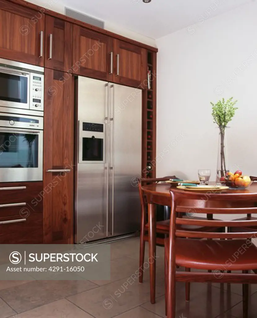 Stainless steel American-style fridge freezer in modern kitchen with circular dining table