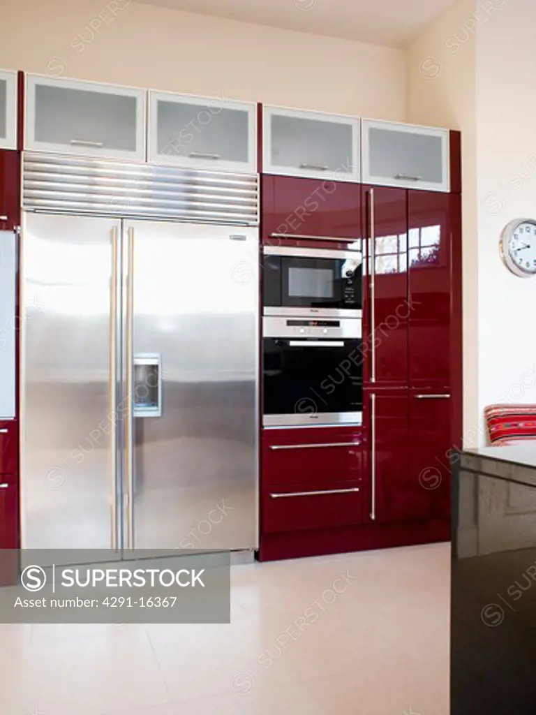Large stainless-steel American-style fridge freezer in modern kitchen with double oven in black fitted unit