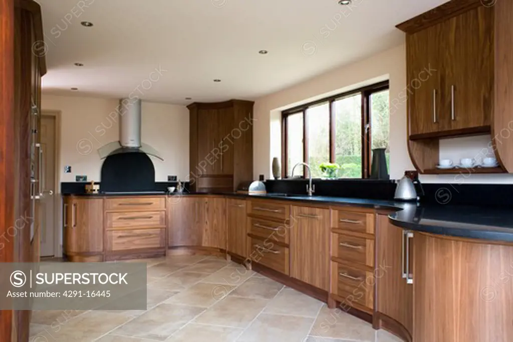 Modern kitchen with fitted walnut units and limestone tiled floor