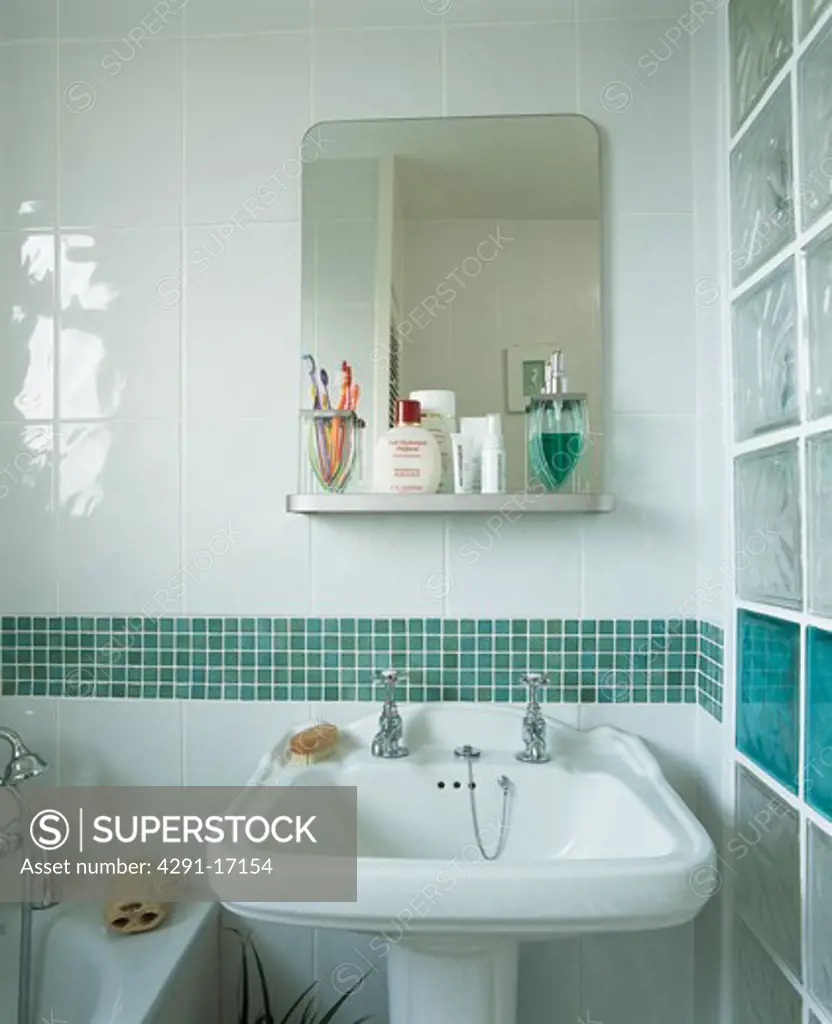 Turquoise tiled border above basin in modern white tiled bathroom