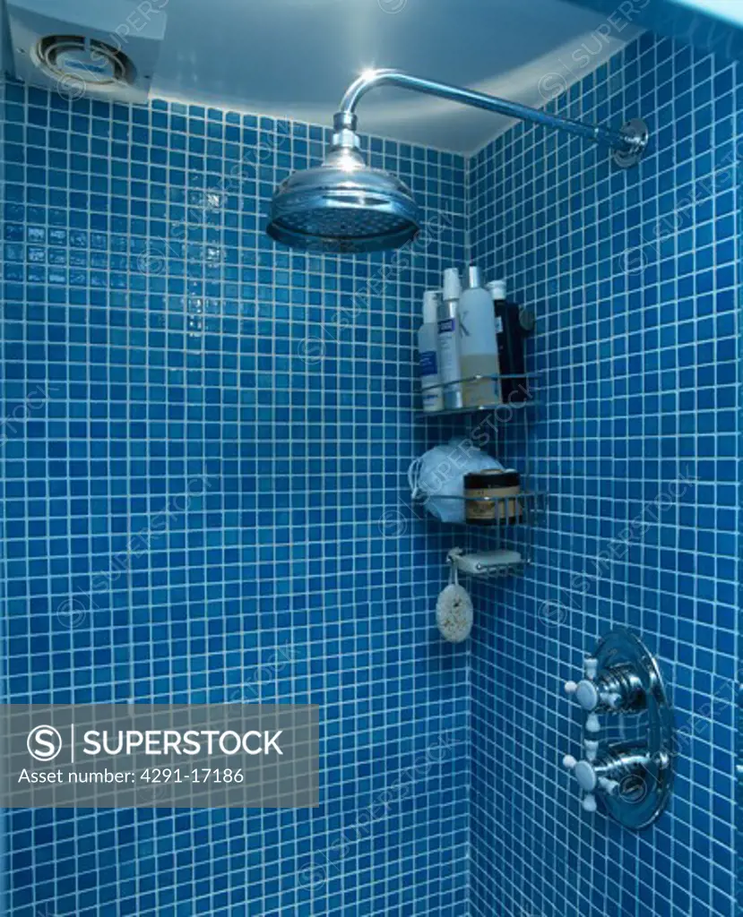 Close-up of shower-head in blue tiled shower in modern blue bathroom