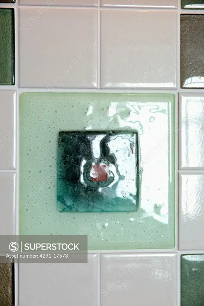 Close-up of green glass and white ceramic tiles