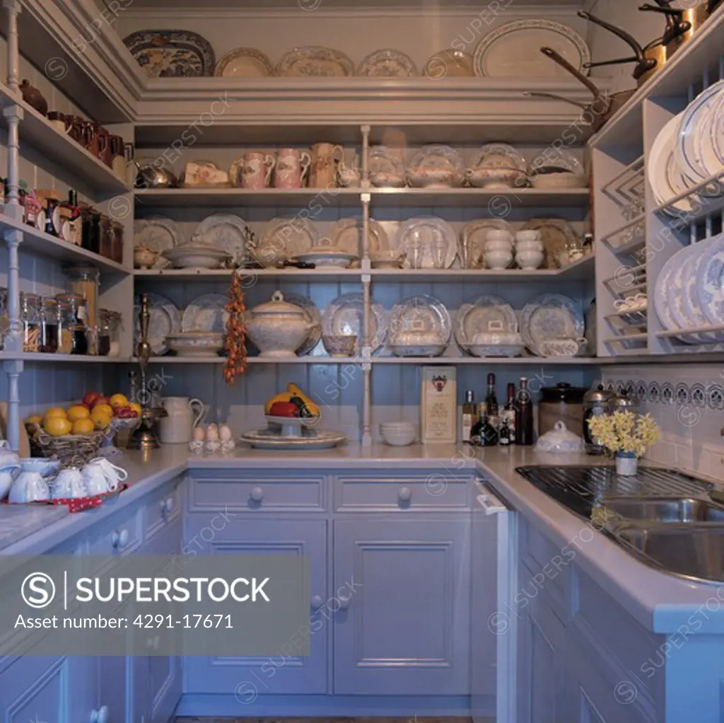 White and blue galley kitchen with china on open shelves