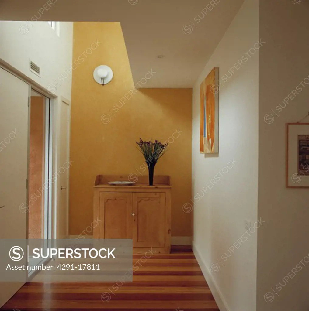 Yellow andwhite painted modern hallway with striped effect wooden board floor