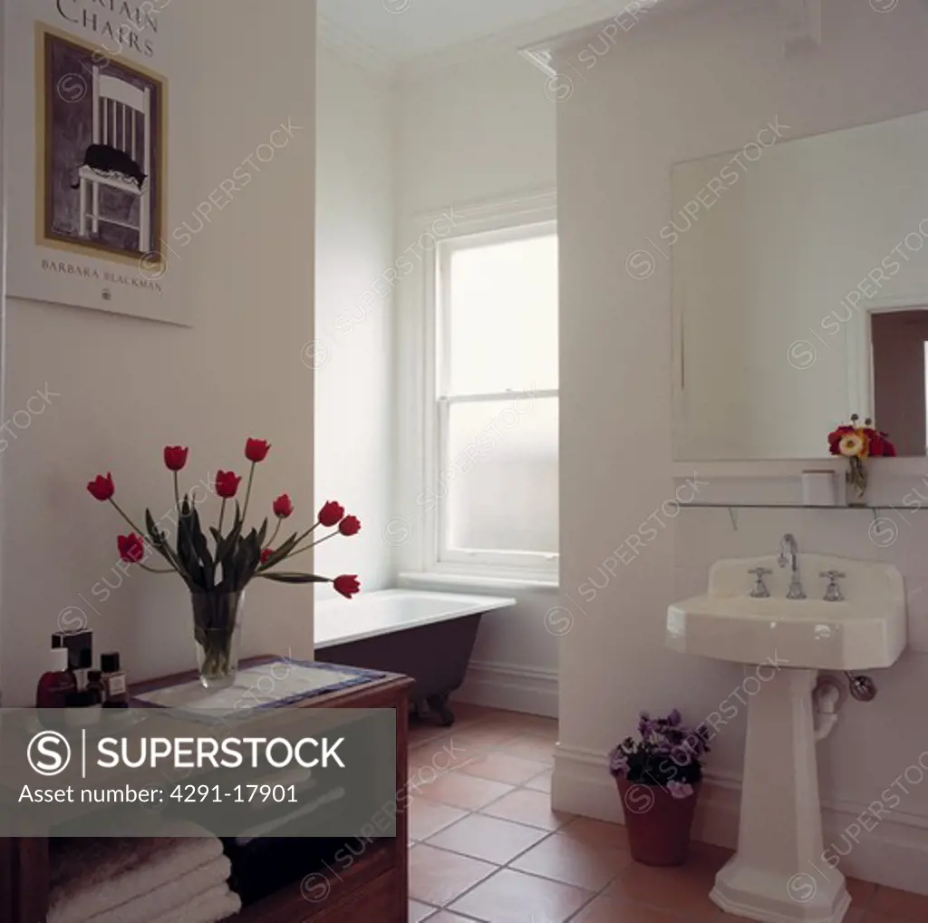 White tiled openplan traditional bathroom with with rolltop bath and terracotta floor tiles