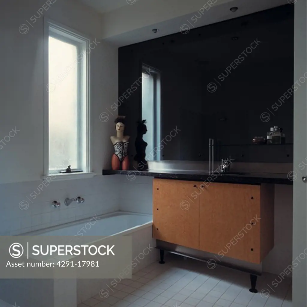 Modern black and white bathroom with black granite-topped wood vanity unit