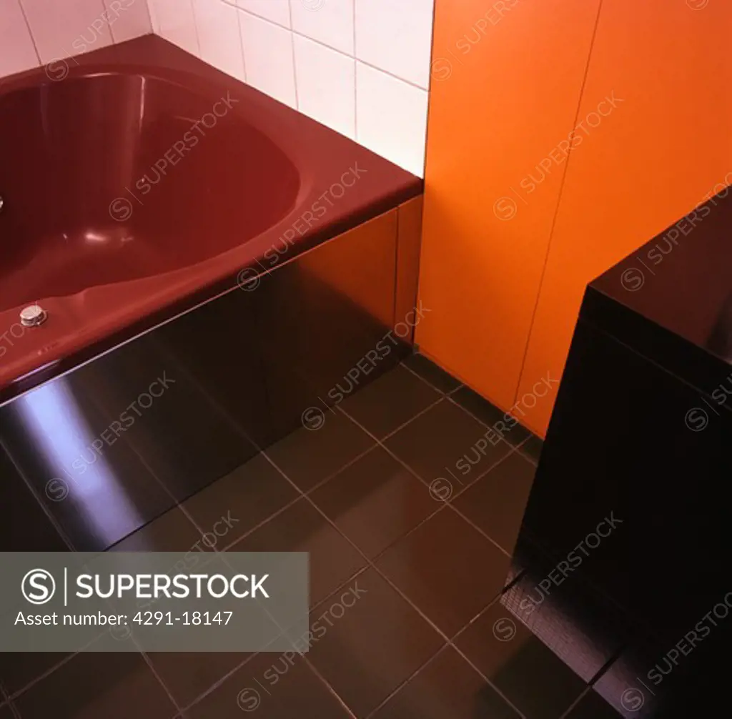 Red bathin orange and white and white bathroom with green floor tiles