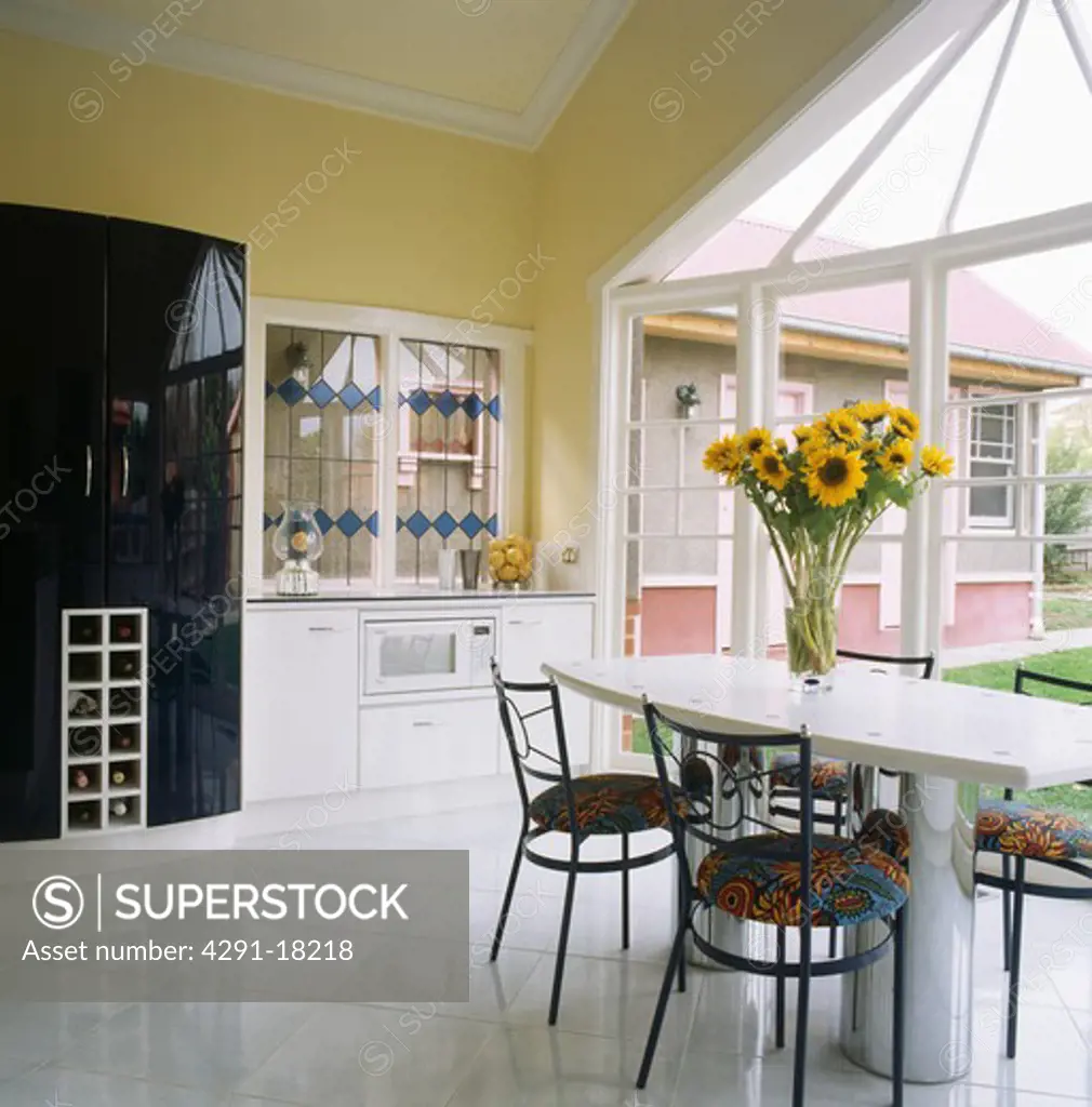 White ceramic floor tiles in modern kitchen with floral upholstered chairs