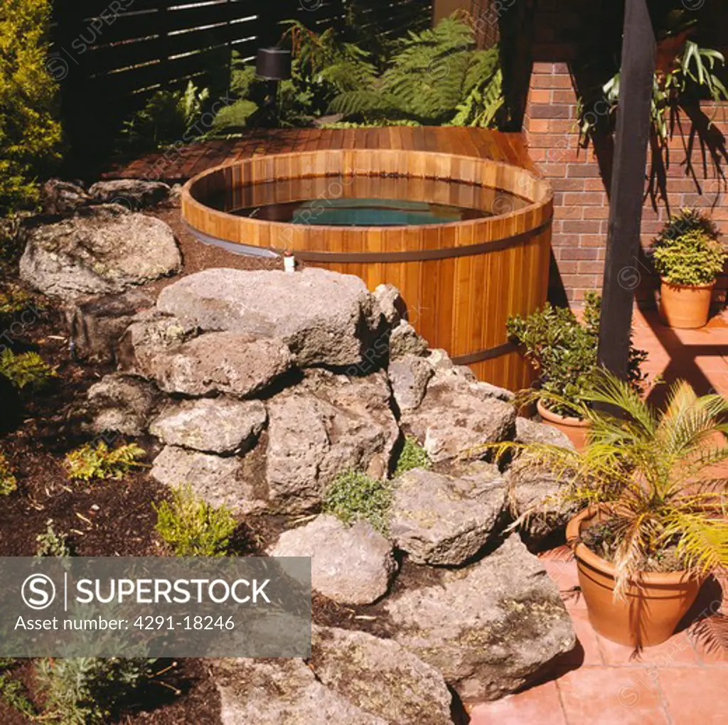 Outdoor wood hot tub with surrounding rockery