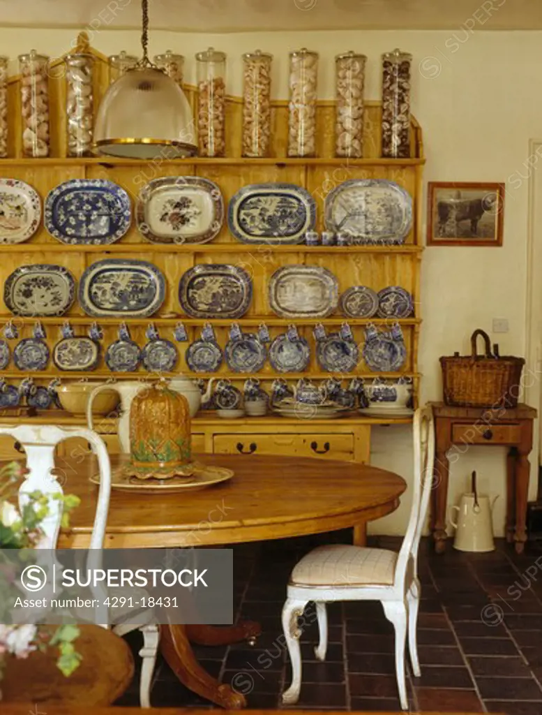 Glass storage jars and blue plate collection on dresser in Victorian-style dining room