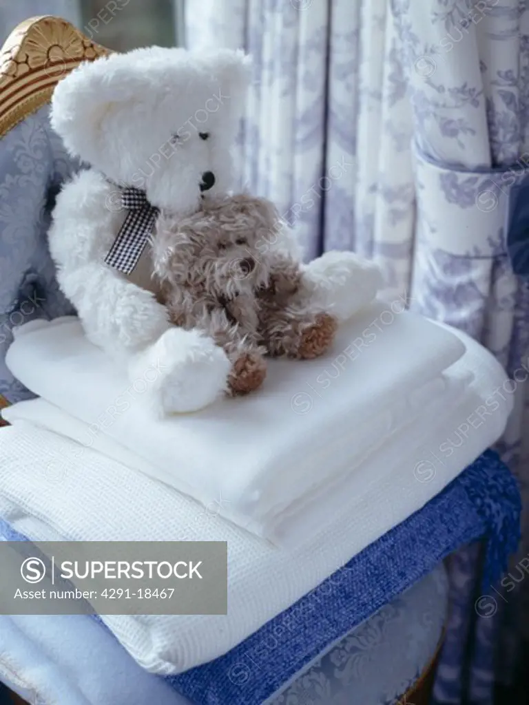 Close-up of teddybears on pile of white blankets
