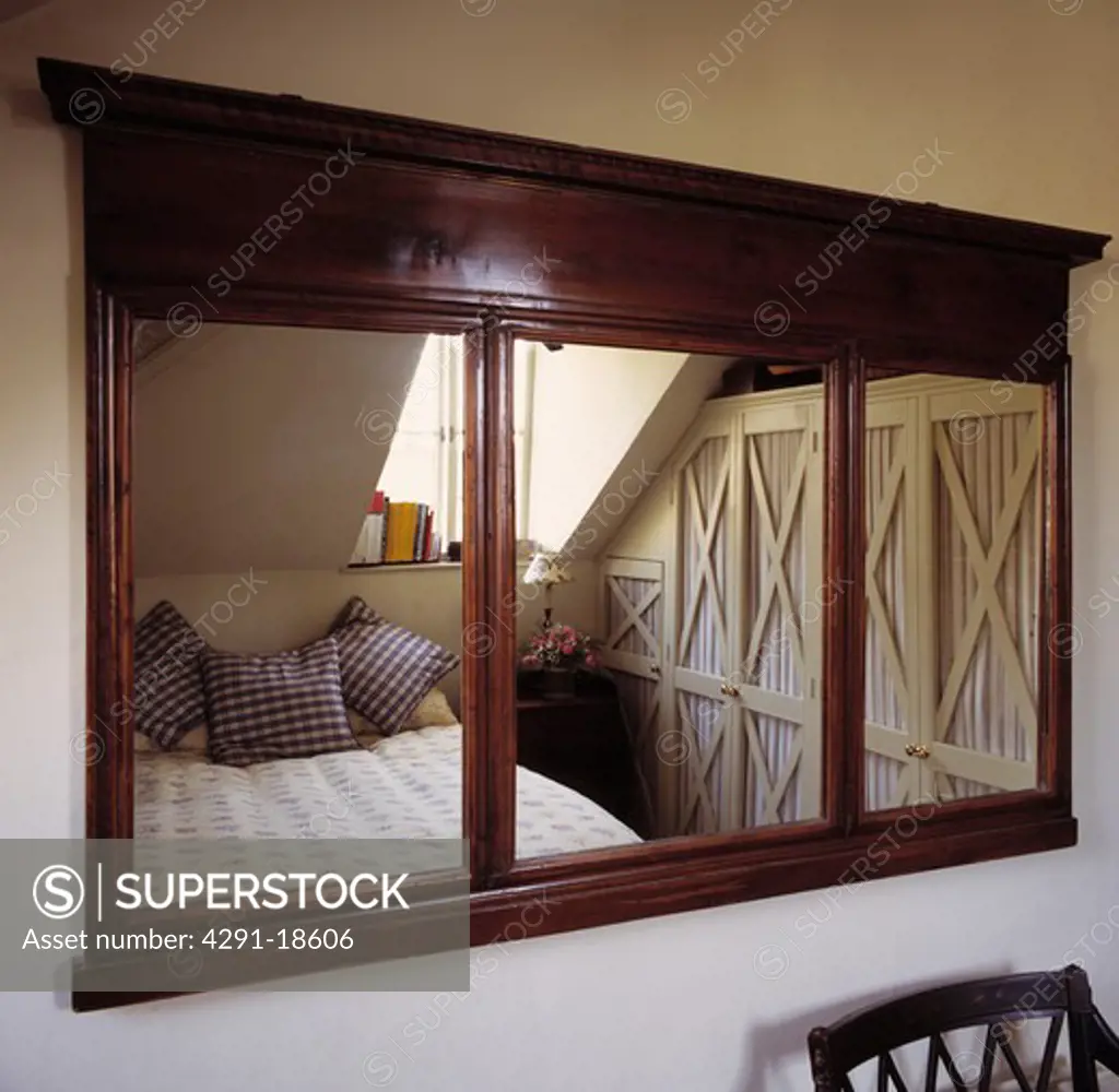 Antique mahogany mirror with reflection of attic bedroom