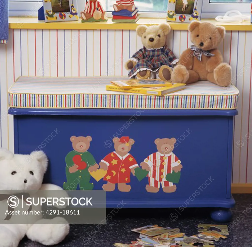 Teddybears sitting on striped cushion on blue chest with painted teddybears