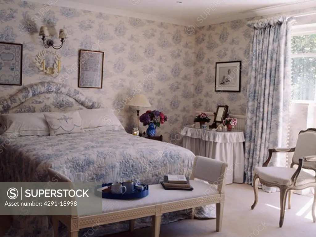 Blue and white Toile-de-Jouy wallpaper and curtains and bedlinen in country bedroom