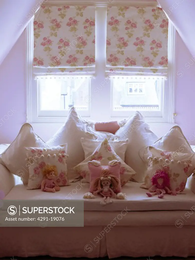 Dormer window with pink floral blinds bove windowseat with matching floral cushions
