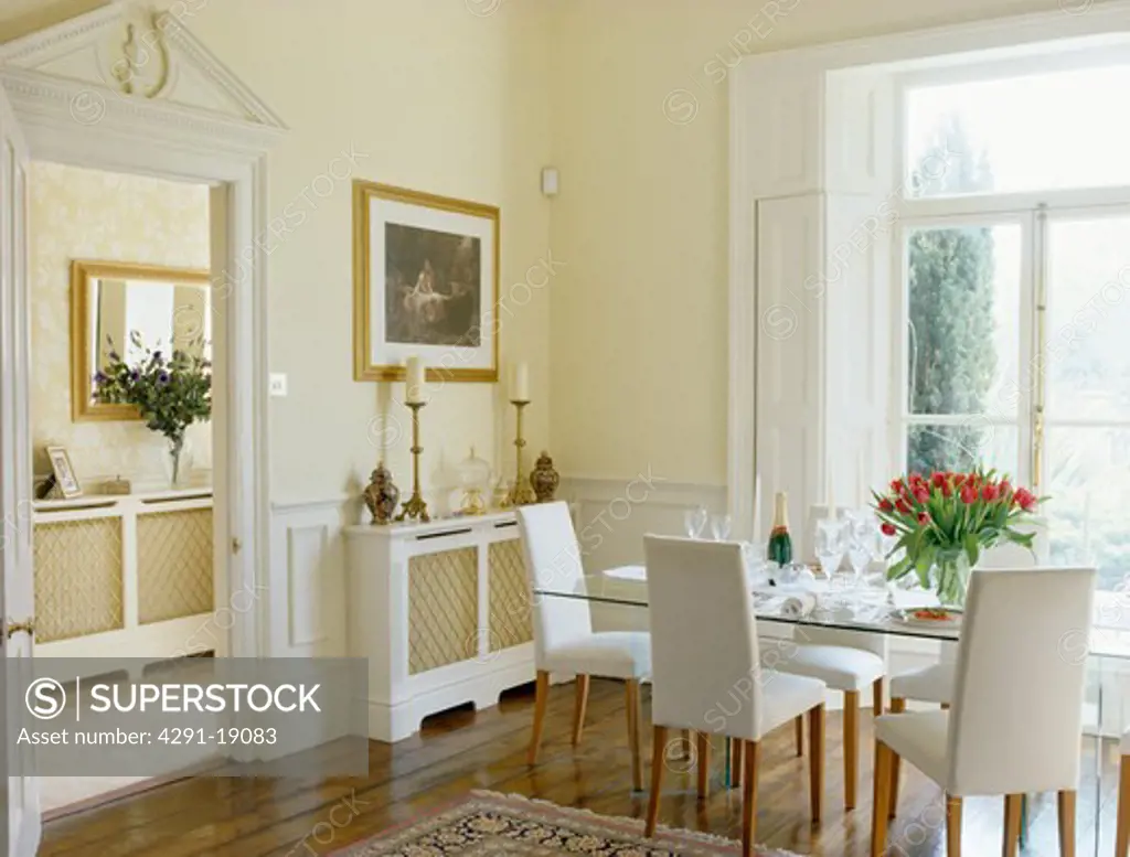 White upholstered chairs in traditional cream dining room