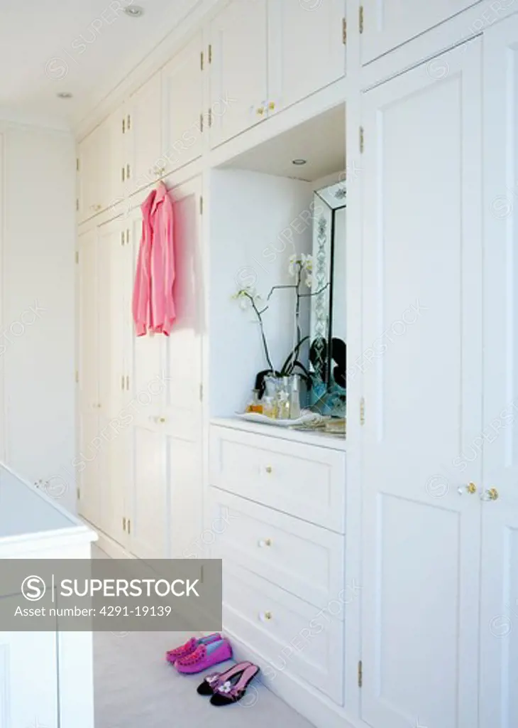 White fitted storage cupboards in traditional dressing room