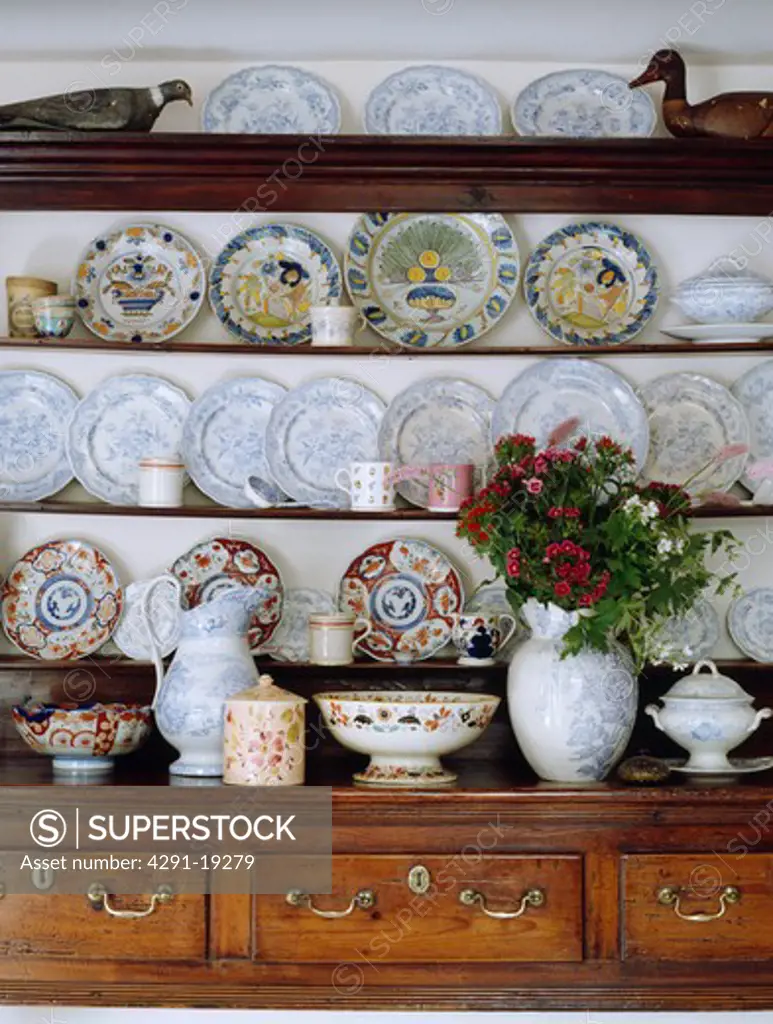 Antique plates on shelves of antique oak kitchen dresser