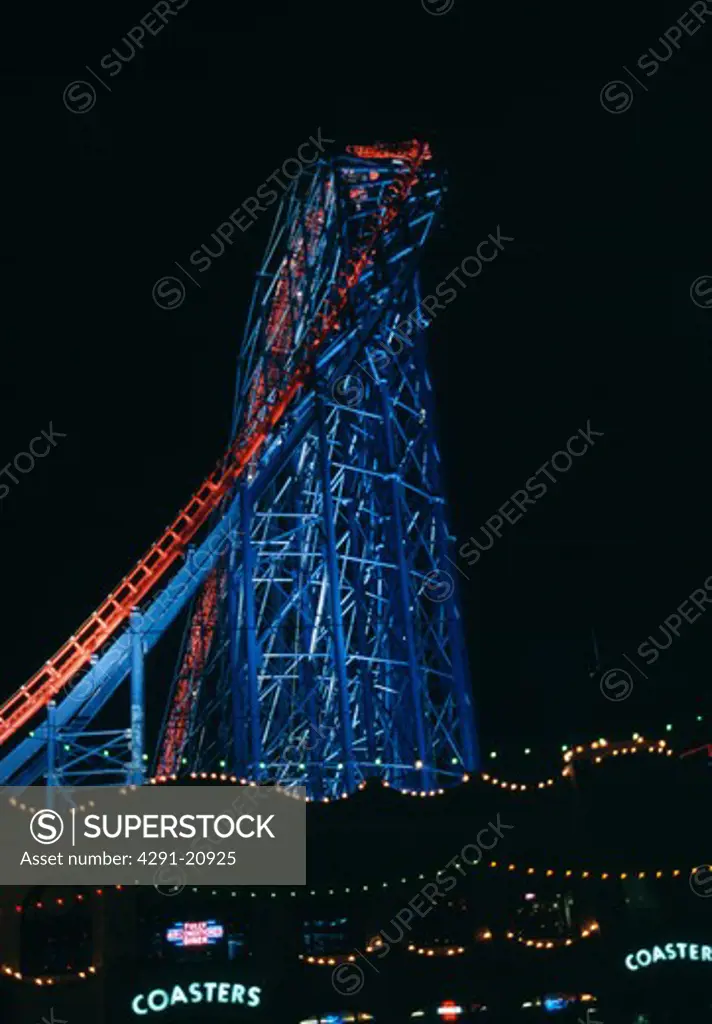 Tall blue rollercoaster lit at night at Blackpool Pleasure Beach in Lancashire