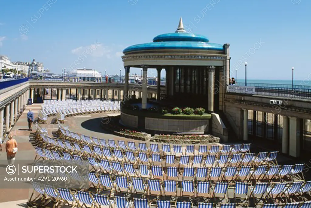 Striped deckchairs in a semi circle around the bandstand on the promenade at Eastbourne in Sussex