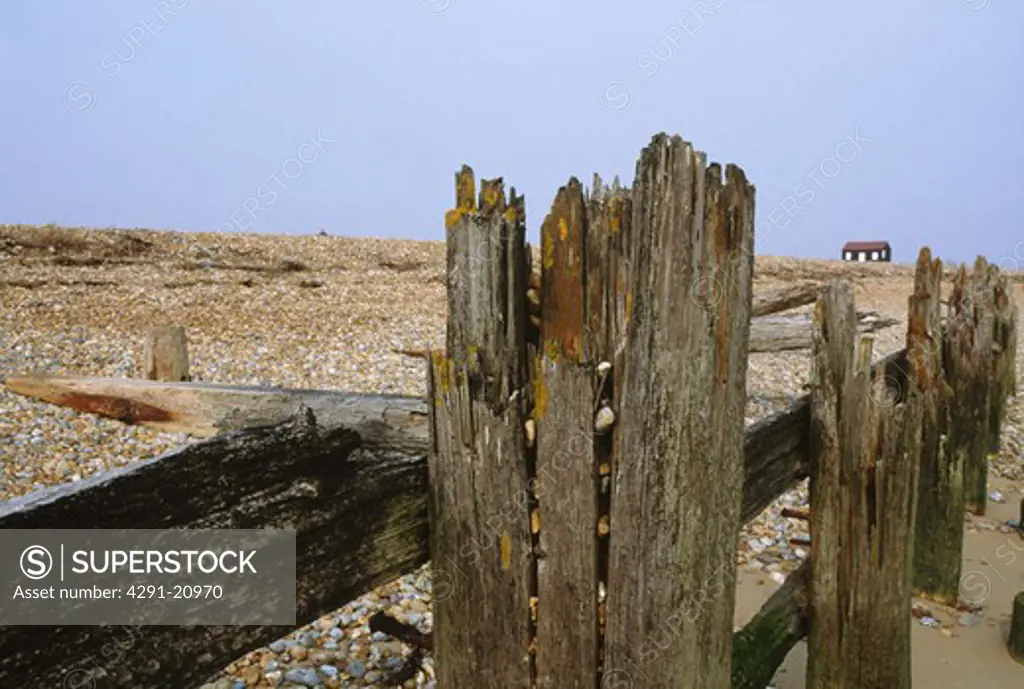 Dilapidated wooden breakwater on shingle beach at Rye in Kent
